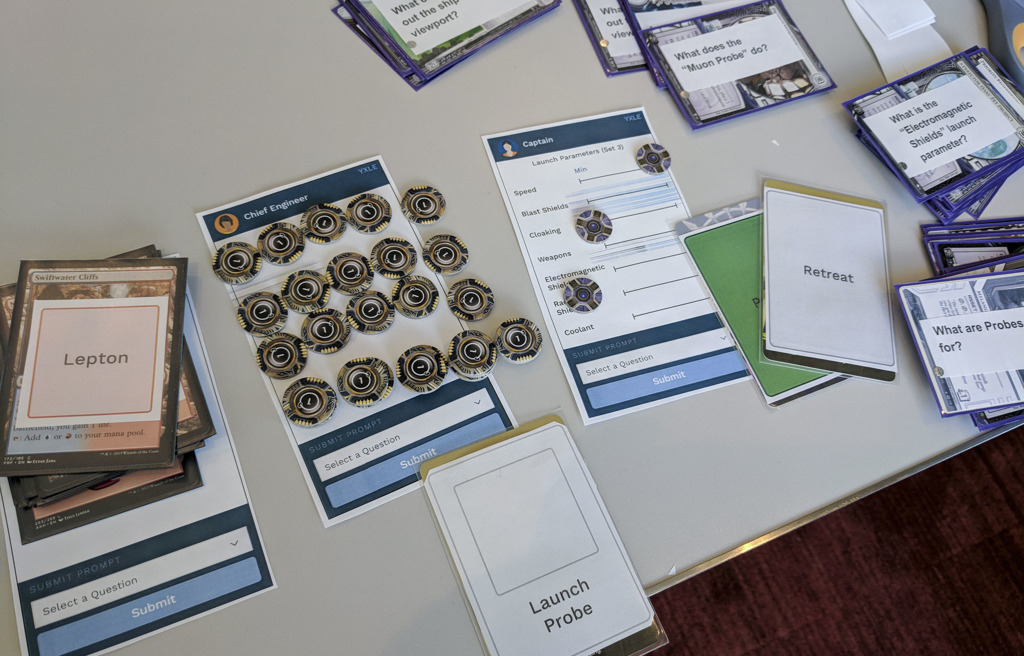 Paper prototypes and repurposed board game tokens used during the first play test.